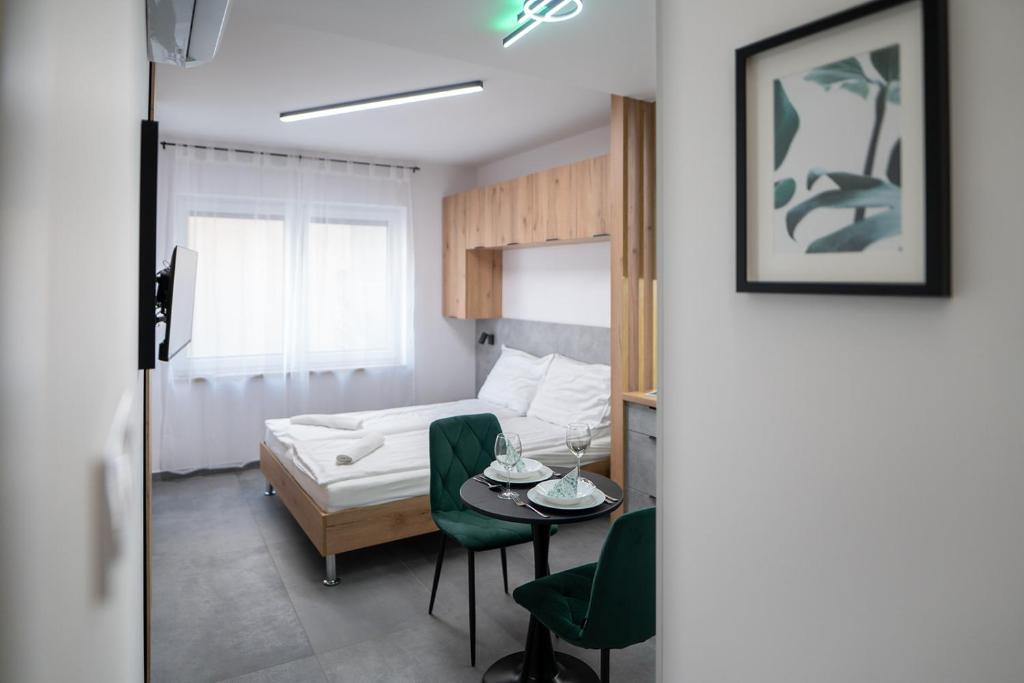 a room with a bed and a table and a bed and a room at AApartman Prime in Pécs