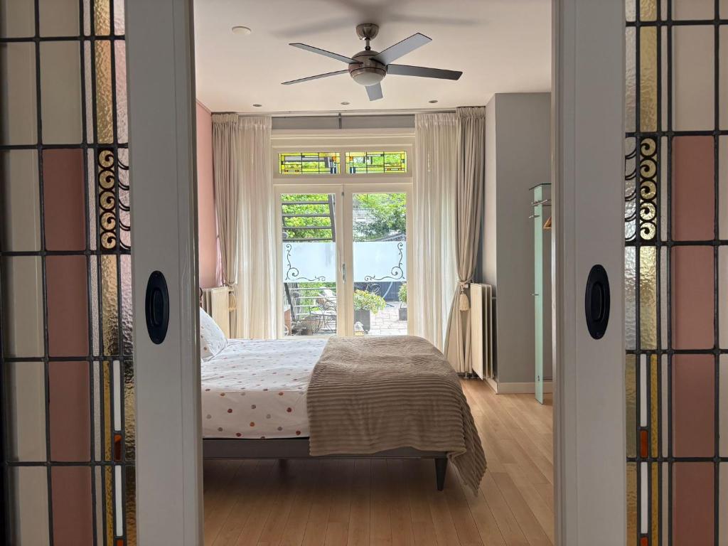 a bedroom with a bed and a window at Sfeervol appartement met tuin bij centrum & station in Dordrecht