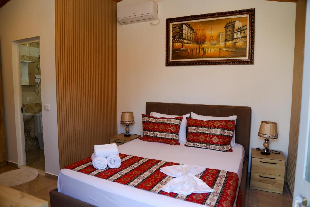 a bedroom with a bed with two towels on it at Lake Bliss Cabins in Shkodër