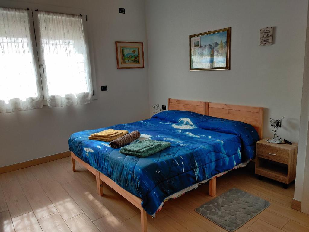 a bedroom with a bed with a blue comforter at Casa Bruzio B&B in San Giorgio di Piano