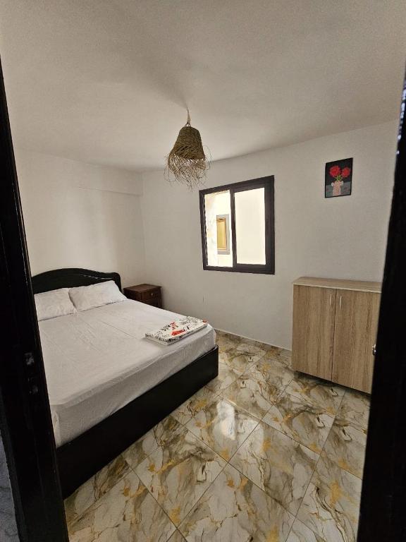 a bedroom with a bed and a window and a floor at ADAGHAS studio 1,3 in Agadir