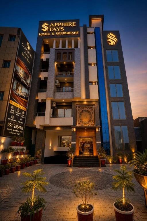 a large building with trees in front of it at Sapphire Stays Hotel And Restaurant in Peshawar