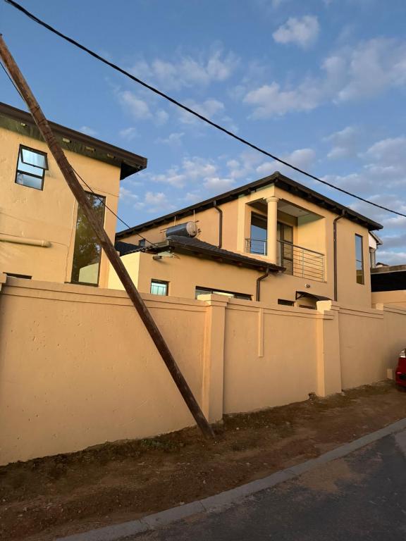 a house with a white fence and a fence at Be my guest in Roodepoort