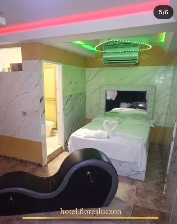 a bedroom with a bed with a green wall at HOTEL FLORES LUCXON, ca in Caracas