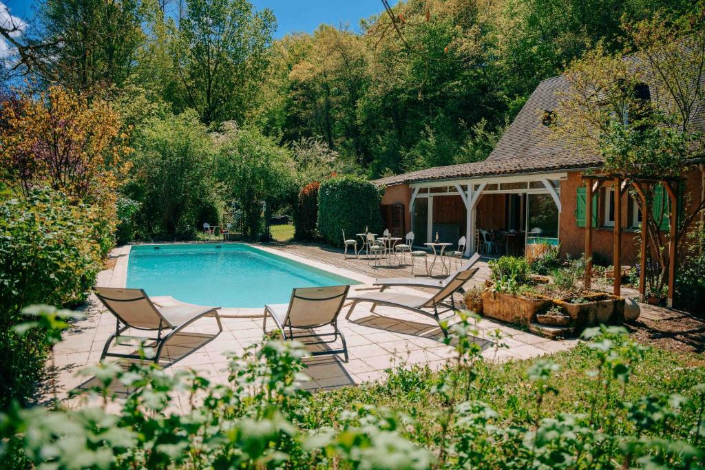 a swimming pool in a yard with chairs and a gazebo at Maison Forenea chambres d'hôtes dans les bois avec petits déjeuners BIO in Sainte-Nathalène