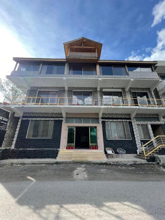 a large building with a balcony on top of it at Hillside Cottages, Kala Bagh in Nathia Gali