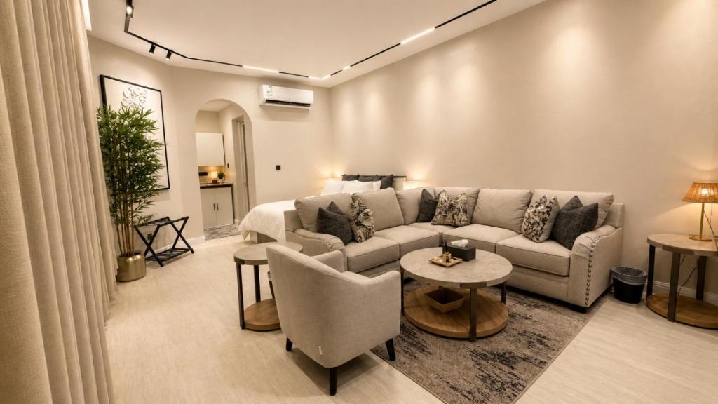 a living room with a couch and a bed at Sukoon Al Jubail in Al Fanātīr