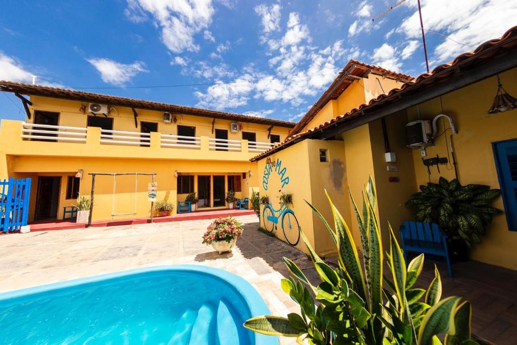 a house with a swimming pool in front of it at Pousada Costa do Mar in Luis Correia