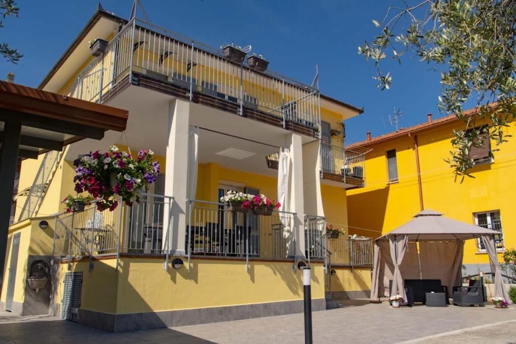 a yellow building with flower boxes on the balconies at LE GEMME Bed & Breakfast con parcheggio e giardino in Casarza Ligure