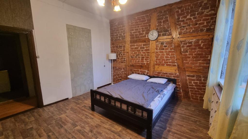 a bedroom with a bed and a brick wall at Helme mõis in Helme