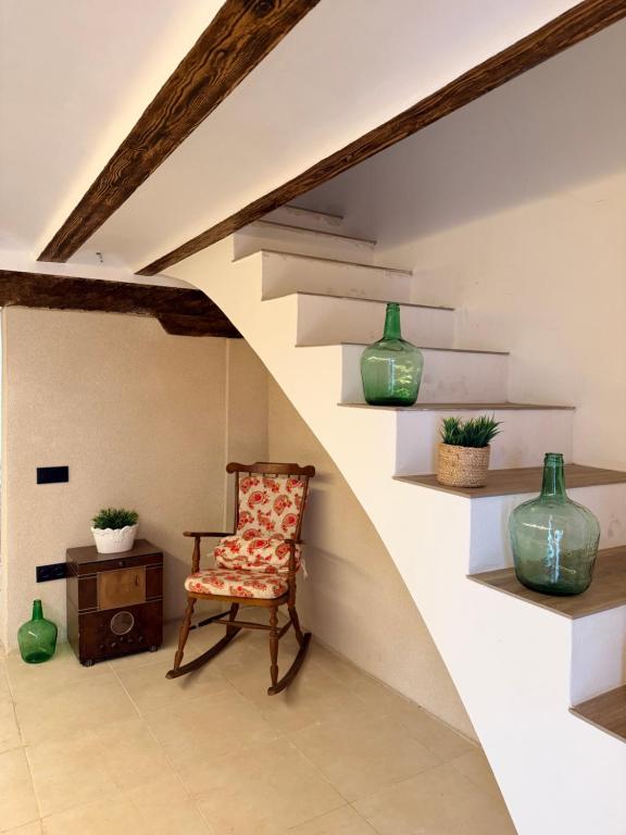 a room with a chair and vases on shelves at Casa Inés in Xerta