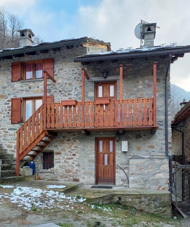 a stone building with a wooden deck on it at Casa Allegra in Pont-Saint-Martin