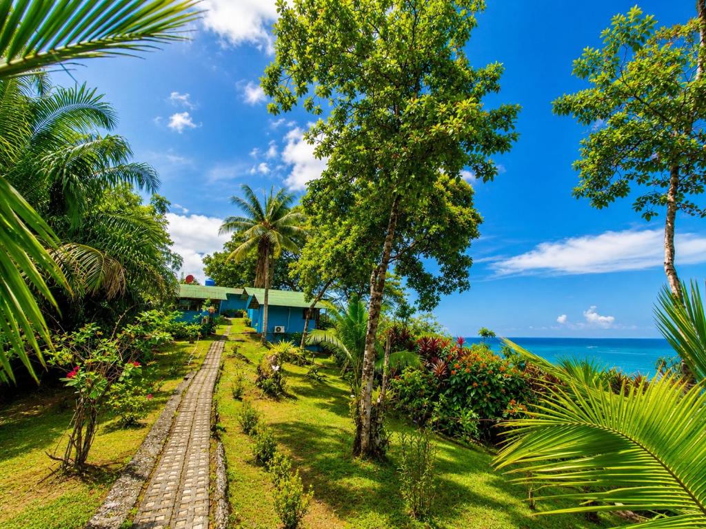 a pathway leading to a resort with the ocean in the background at Casa Jade in Drake