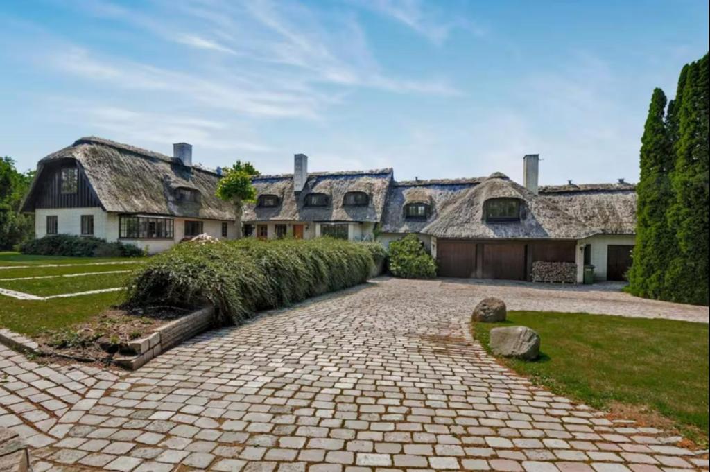 a large house with a brick driveway in front of it at Skovgaardsvej 7 in Udby