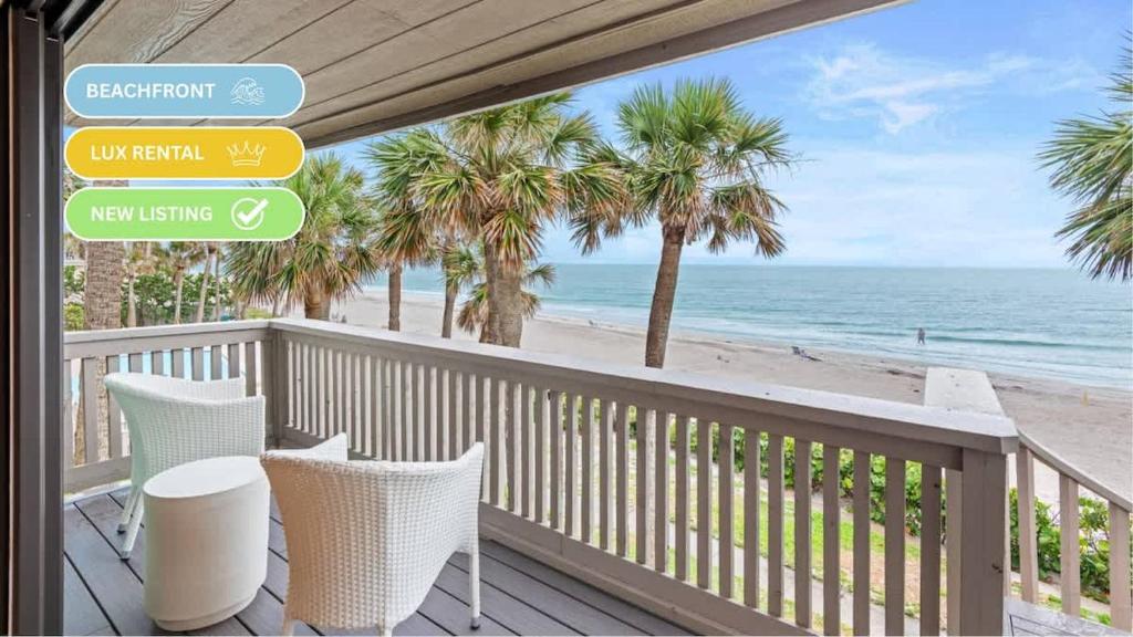 a balcony with a view of the beach and palm trees at Beachfront Aldea 12 in Clearwater Beach