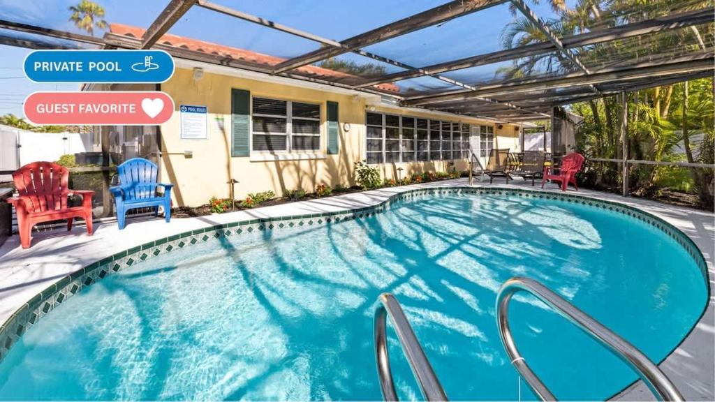 a swimming pool with chairs and a house at Sunset Beach House in Clearwater Beach