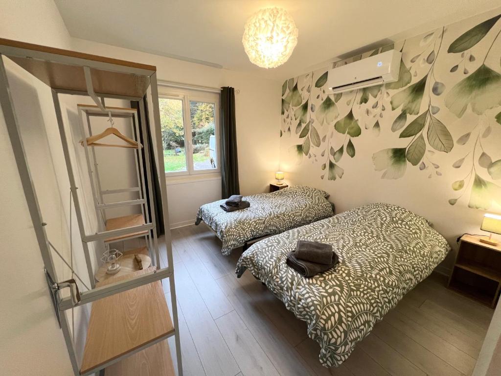 a bedroom with two beds and a window and a shelf at La Maison de Miel in Beynat