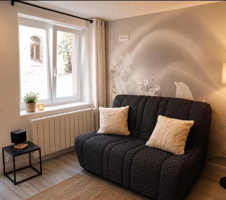 a living room with a couch and a window at Nuit étoilée - Dormir Comme A La Maison in Saint-Julien-de-Vouvantes