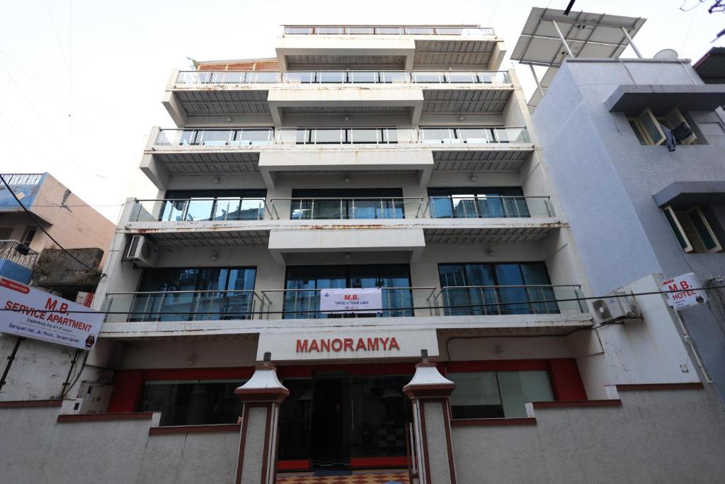 a large white building with a sign on it at MB hotel in Rajkot