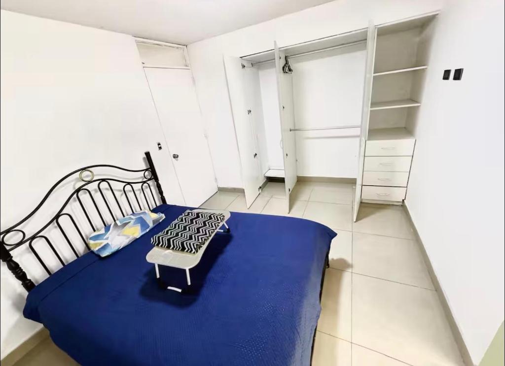 a bedroom with a bed with a blue blanket on it at Studio Brasil 861 in Lima