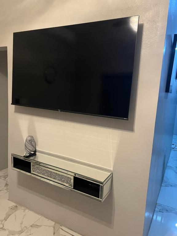 a flat screen tv hanging on a wall at Op paradise living in Kingston