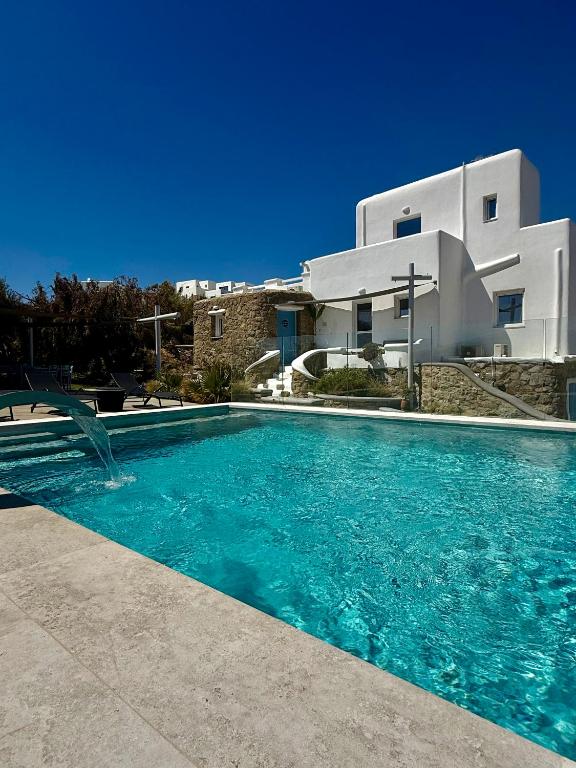 a villa with a swimming pool in front of a building at Villa Greystone & Sky Mykonos in Tourlos