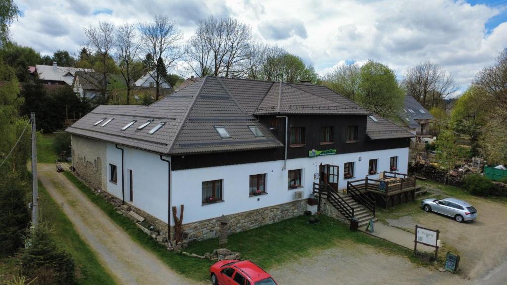 a house with a car parked in front of it at Penzion U Peňázů in Tři Studně
