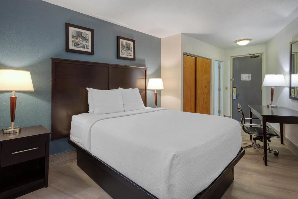 a bedroom with a large bed and a desk at Best Western Gregory Hotel in Brooklyn
