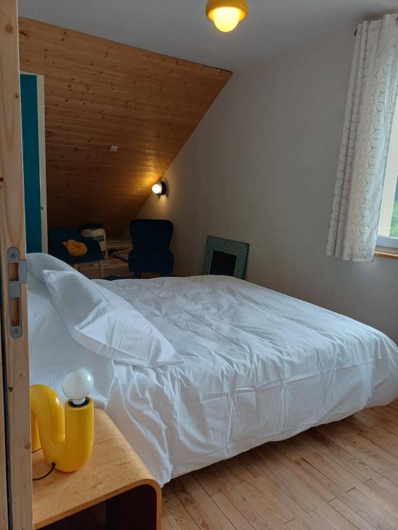 a bedroom with a large white bed in a room at Soleil Bleu in Saint-Racho