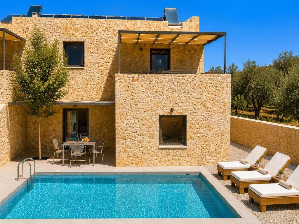 a villa with a swimming pool in front of a building at Villa Castillo Thio in Agios Nikolaos