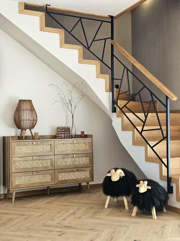 a living room with a staircase and two ottomans at Apartamenty Klikuszówka in Nowy Targ