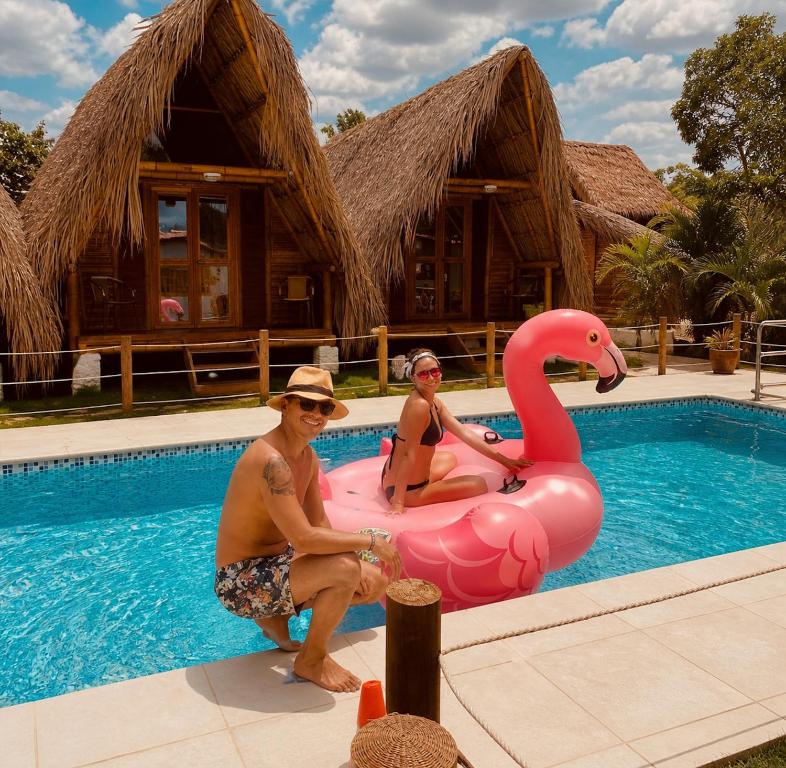 two people sitting on a pink flamingo in a pool at Palomino Sunrise in Palomino