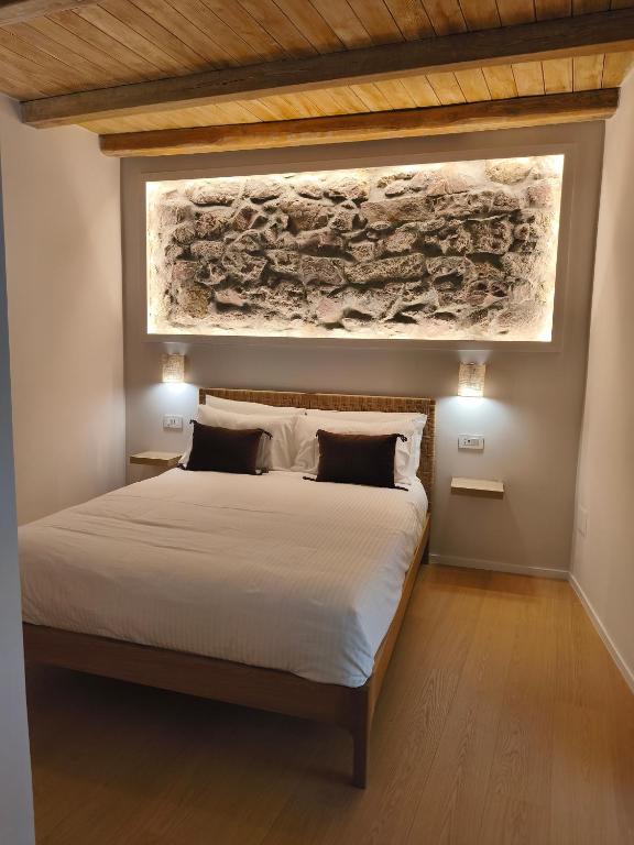 a bedroom with a bed with a painting on the wall at Insula Domo in Nuoro