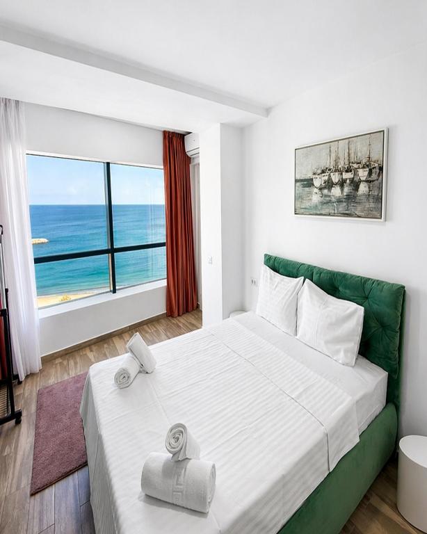 a bedroom with a large bed and a large window at Olimp Sea View Apartments by Maritimo in Olimp
