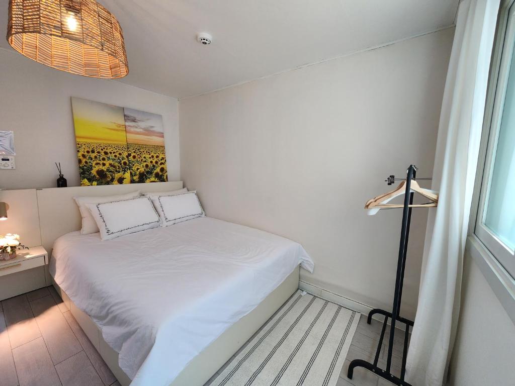 a small bedroom with a white bed and a window at 코지룸 in Seoul