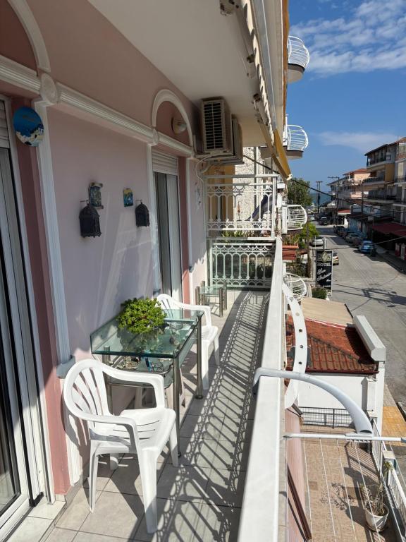 a balcony with a table and chairs on a building at Pieria Paralia Apartment in Paralia Katerinis