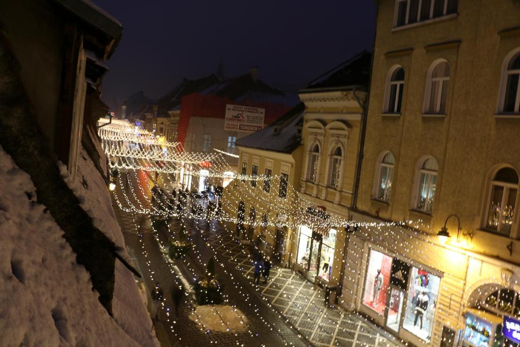a street filled with christmas lights at night at Republicii Apartment in Braşov