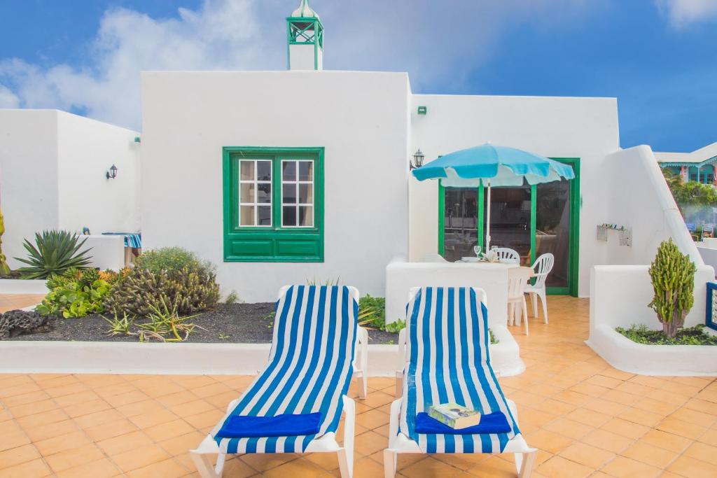 two blue and white chairs and a table and umbrella at Apartamentos Sal y Mar in Puerto del Carmen