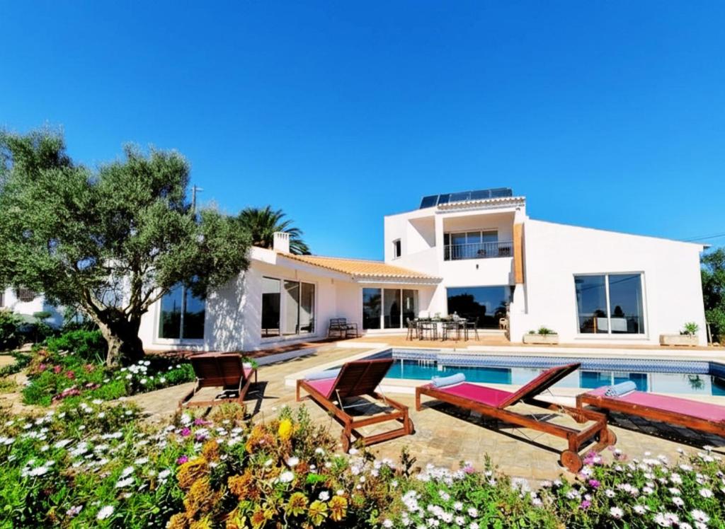 a villa with a swimming pool and a house at Casa da Madrugada in Salema