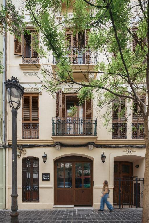 a woman walking in front of a building at Suites 43 Juan Llorens in Valencia