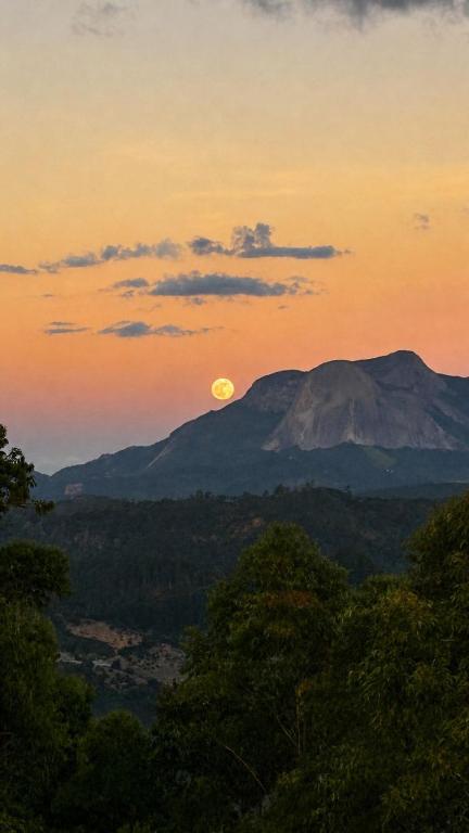 a view of a mountain with the moon in the sky at Chalés Mirante da Colina in Venda Nova do Imigrante