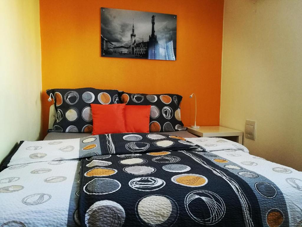 オロモウツにあるApartmán 4U Olomoucのベッドルーム1室(オレンジ色の壁の大型ベッド1台付)