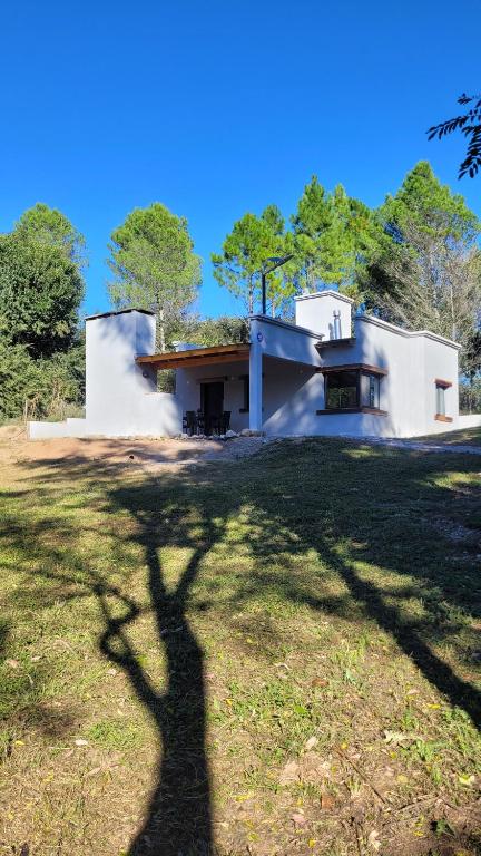 a shadow of a tree in front of a house at La Pausa Córdoba, casa en Los Reartes in Los Reartes