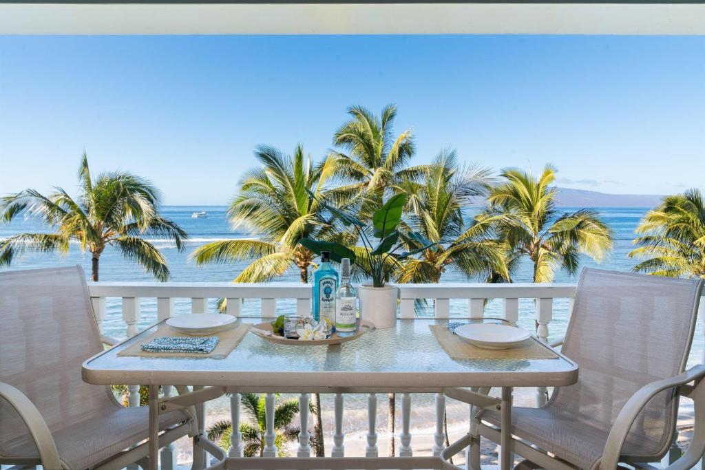 a table on a balcony with a view of the ocean at Lahaina Shores 517 in Lahaina