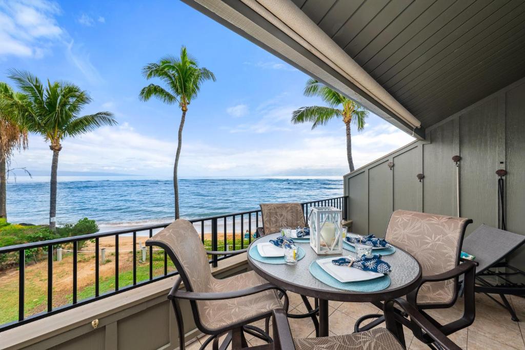 a patio with a table and chairs and the ocean at Kahana Village 4 in Lahaina