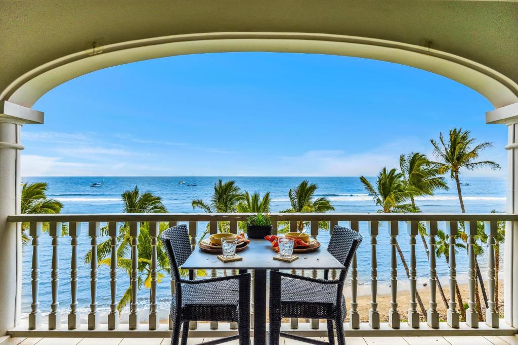 a table on a balcony with a view of the beach at Lahaina Shores 631 in Lahaina