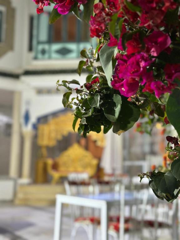 a bunch of pink flowers in front of a white chair at Morjana Castle in Sousse