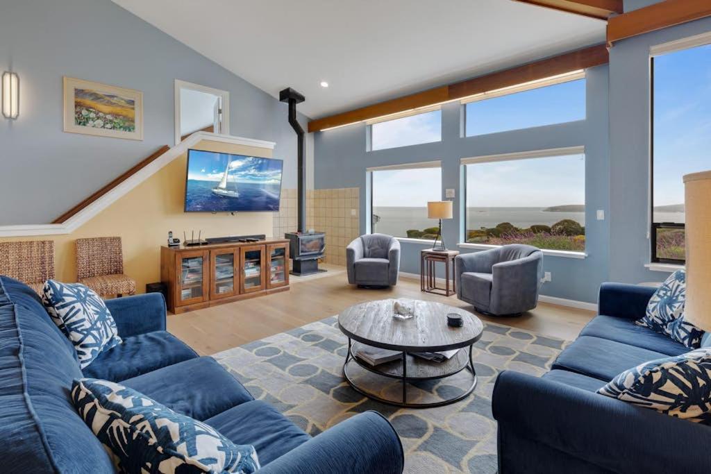 a living room with blue couches and a table at Eagle's Nest in Bodega Bay
