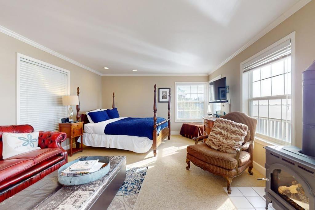 a bedroom with a bed and a living room with a fireplace at Bayside Cottage in Bodega Bay