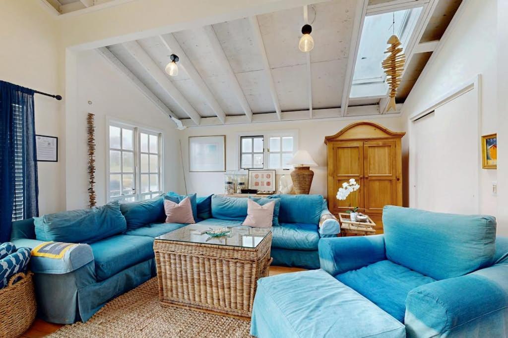 a living room with a blue couch and a table at Mar-Tiny in Bodega Bay